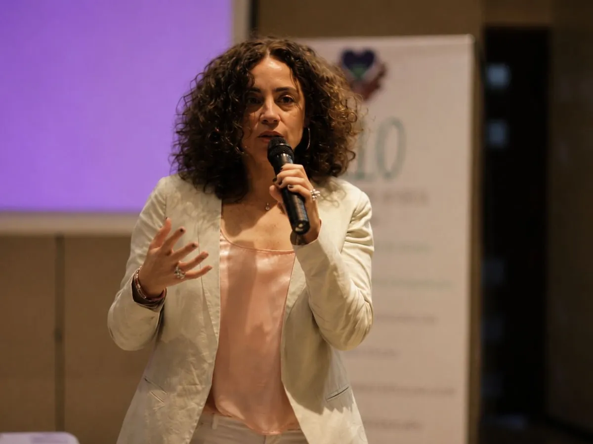 Ana Edith Cuquejo hablando con micrófono en un escenario